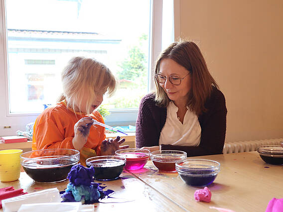Erzieherin und Kind beim Experimentieren
