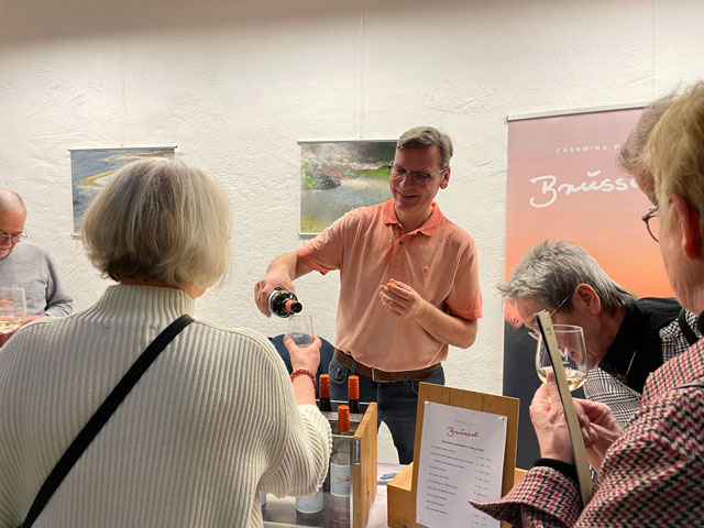 Gäste beim Verkosten von Wein bei der Weinmesse im Lichthof der vhs Delmenhorst