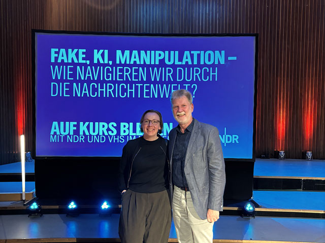 Dr. Grit Fisser und Geschäftsführer Jürgen Beckstette im NDR Landesfunkhaus Hannover vor einem großen Bildschirm, der das Thema des Abends anzeigt.