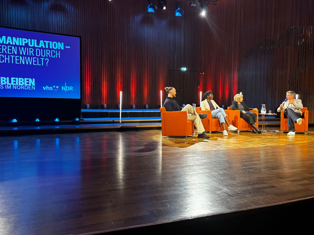 Pascal Siggelkow, verantwortlicher Redakteur des ARD-Faktenfinders, Joyce Noufélé, Bereichsleiterin Digitalisierung der vhs Osnabrück, Medienwissenschaftlerin Prof. Dr. Caja Thimm mit Moderator Arne-Torben Voigts auf der Bühne in einer Diskussion.